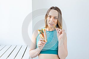 Diet concept - Healthy lifestyle woman eating vegetables smiling happy indoors. Young female eating healthy food.