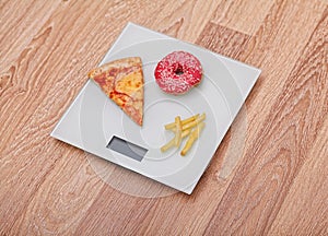 Diet. The concept of junk food on weight. Healthy Lifestyle. Wooden background.