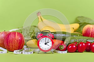 Diet concept for loosing weight with only eating healthy food at certain times with vegetables, fruits, measuring tape and clock