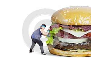 Overweight man pushing big burger