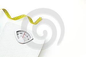 Diet concept with scale and measuring tape for weight loss on white background top view mock up