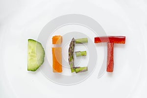 Diet concept. White plate with word - diet - composed of slices of different fruits and vegetables