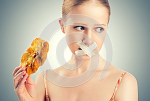 Diet concept. woman mouth sealed with duct tape with buns