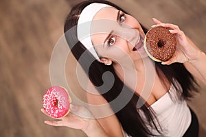 Diet Concept. Young Woman Measuring Body Weight On Weighing Scale While Holding Glazed Donut With Sprinkles. Sweets Are Unhealthy