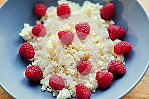 Diet curd with raspberry on a plate. At the kitchen