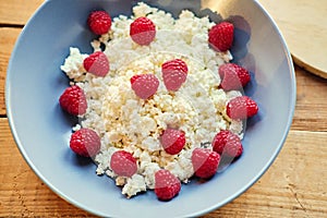 Diet curd with raspberry on a plate. At the kitchen