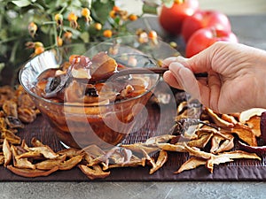 Diet dessert for the elderly. Elderly woman`s hand holds a spoon with fruit homemade jelly.Cooking process using starch and dried