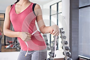 Diet and dieting. Beauty slim female body use tape measure. Woman in exercise clothes achieves weight loss goal for healthy life,