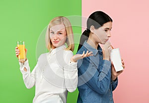 Diet. Dieting concept. Healthy Food. Beautiful Young Women choosing between fruit orange juice and unhelathy carbonated