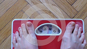 Diet. Excess weight. Thin Man stepping on a scales