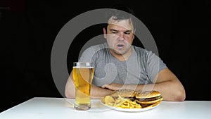 Diet failure of fat man eating fast food hamberger. Happy smile overweight person who spoiled healthy food by eating