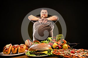 Diet fat man makes choice between healthy and unhealthy food. photo
