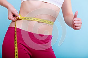 Diet. Fitness woman fit girl with measure tape measuring her waist