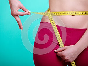 Diet. Fitness woman fit girl with measure tape measuring her waist