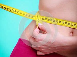 Diet. Fitness woman fit girl with measure tape measuring her waist