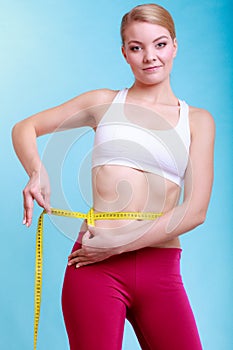 Diet. Fitness woman fit girl with measure tape measuring her waist