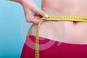 Diet. Fitness woman fit girl with measure tape measuring her waist