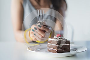 Diet for good health concept. Woman tied her hand and restraint do not to eat sweet food