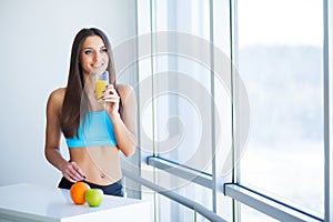 Diet. Happy smiling young woman drinking orange juice
