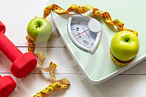 Diet and Healthy life loss weight Concept. Green apple and Weight scale measure tap with fresh vegetable