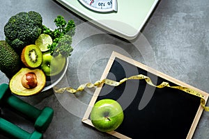 Diet and Healthy life loss weight Concept. Green apple and Weight scale measure tap with fresh vegetable and sport equipment for w