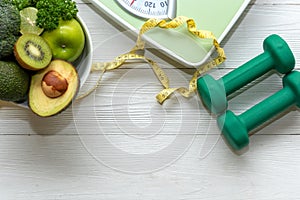 Diet and Healthy life loss weight Concept. Green apple and Weight scale measure tap with fresh vegetable and sport equipment for w