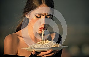 Diet and healthy organic food, italy. Chef woman with red lips eat pasta. Hunger, appetite, recipe. Woman eating pasta