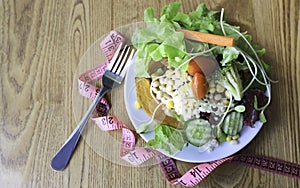 Diet meal. Vegetables salad in  plate with  Measuring tape a Healthy food of salad .Healthy lifestyle Concept