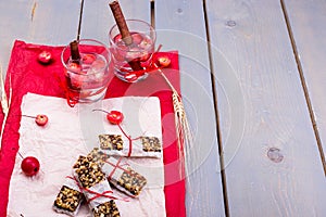 Diet muesli bars with detox apple cinnamon water on red pepper and wooden background.