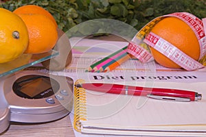 The concept of dieting, losing excess weight. Fruits, Libra, calculator and centimeter on a wooden table