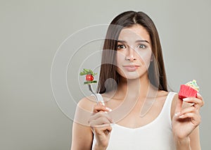 Diet and Overweight Concept. Woman with Cupcake and Vegetable