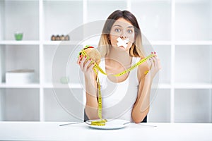 Diet. Portrait woman wants to eat a Burger but stuck skochem mouth, the concept of diet, junk food, willpower in nutrition