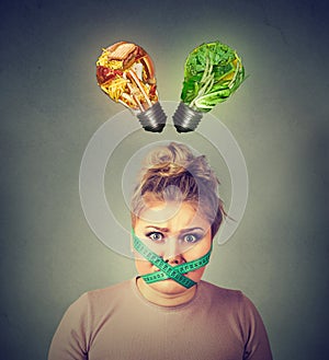 Diet restriction stress. Frustrated woman with measuring tape around her mouth