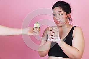 Diet restricts, weight loss, eating disorder concept. overweight fat woman with measure tape cover her mouth while hands of