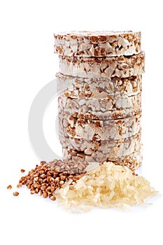 Diet rice cakes pile with buckwheat and rice grains isolated on white background photo