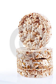 Diet rice cakes pile with buckwheat and rice grains isolated on white background, vertical, selective focus