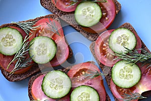 Diet sandwiches made of black flour with tomatoes and cucumber