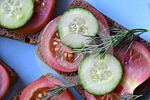 Diet sandwiches made of black flour with tomatoes and cucumber