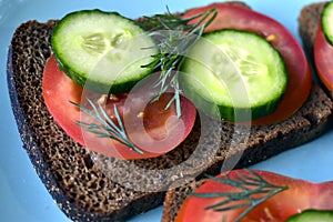 Diet sandwiches made of black flour with tomatoes and cucumber