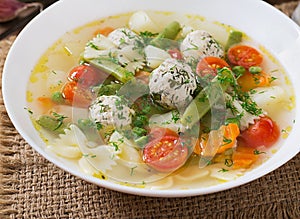 Diet vegetable soup with chicken meatballs and fresh herbs.