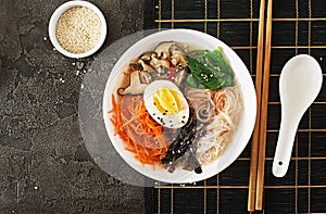 Diet vegetarian bowl of noodle soup of shiitake mushrooms, carrot and boiled eggs. Japanese food. Top view. Flat lay