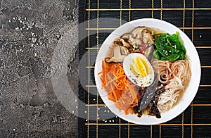 Diet vegetarian bowl of noodle soup of shiitake mushrooms, carrot and boiled eggs. Japanese food. Top view. Flat lay