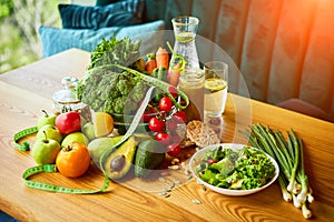 Diet weight loss breakfast concept with tape measure, organic fruits , vegetables, salad and fresh water. Healthy nutrition