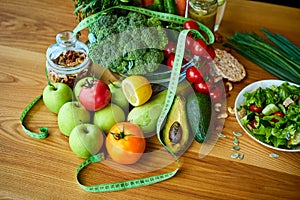 Diet weight loss breakfast concept with tape measure, organic fruits , vegetables, salad and fresh water. Healthy nutrition