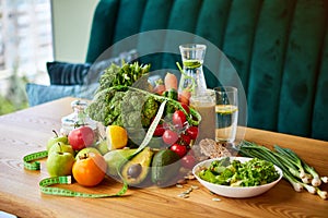 Diet weight loss breakfast concept with tape measure, organic fruits , vegetables, salad and fresh water. Healthy nutrition