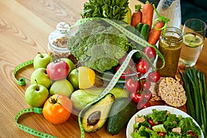 Diet weight loss breakfast concept with tape measure, organic fruits , vegetables, salad and fresh water. Healthy nutrition