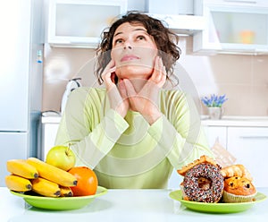 Diet. Woman choosing between Fruits and Sweets