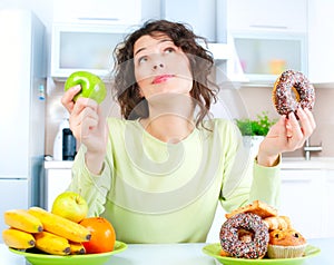 Diet. Woman choosing between Fruits and Sweets