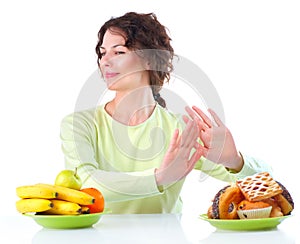 Diet. Woman choosing between Fruits and Sweets