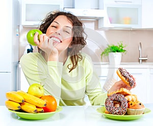 Diet. Woman choosing between Fruits and Sweets